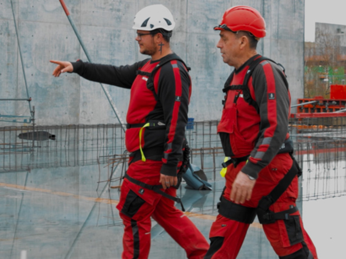 Two mean wearing exoskeletons on an outdoor construction site.